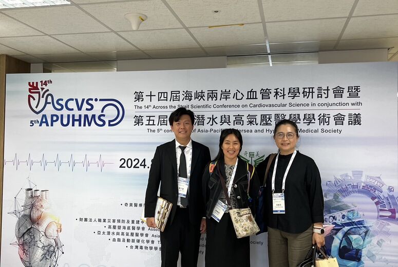 Student with group at a research conference standing in front of a backdrop