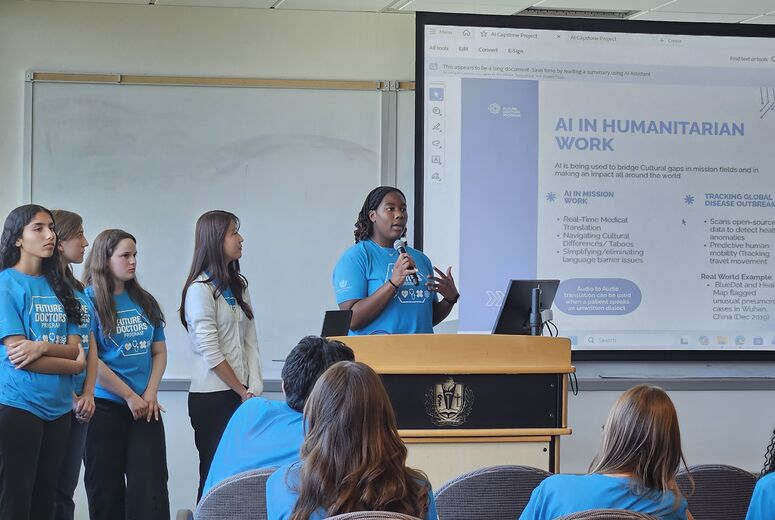 Four students by podium presenting on a topic 