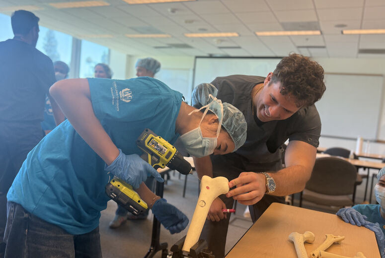 student drilling into artificial bone with a medical students
