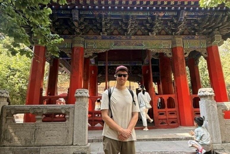 medical student standing at a historical landmark in China.