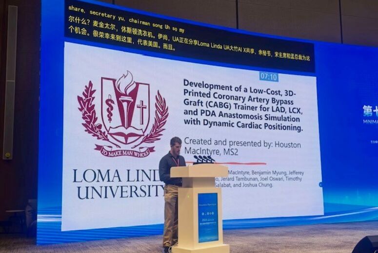 Medical student  in front of digital screen at podium presenting his research
