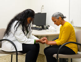 Student praying with patient